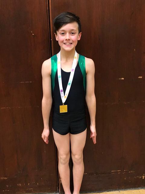 male gymnast at the neon competition with a medal