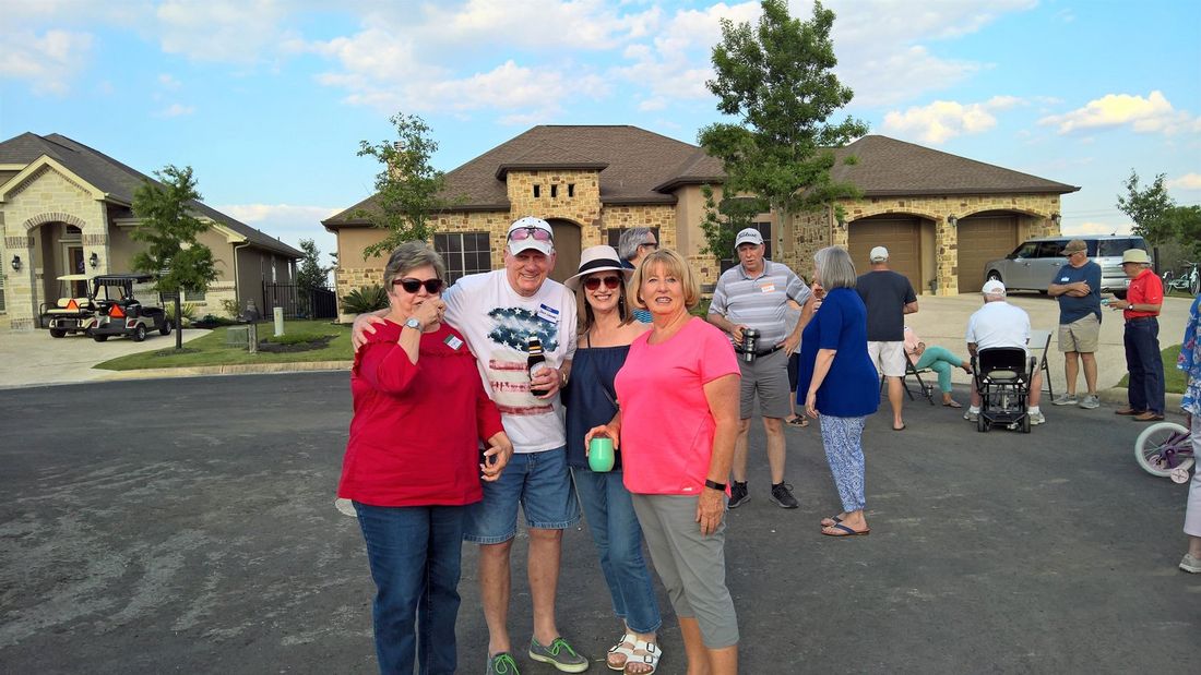 A group of people are posing for a picture in front of a house.