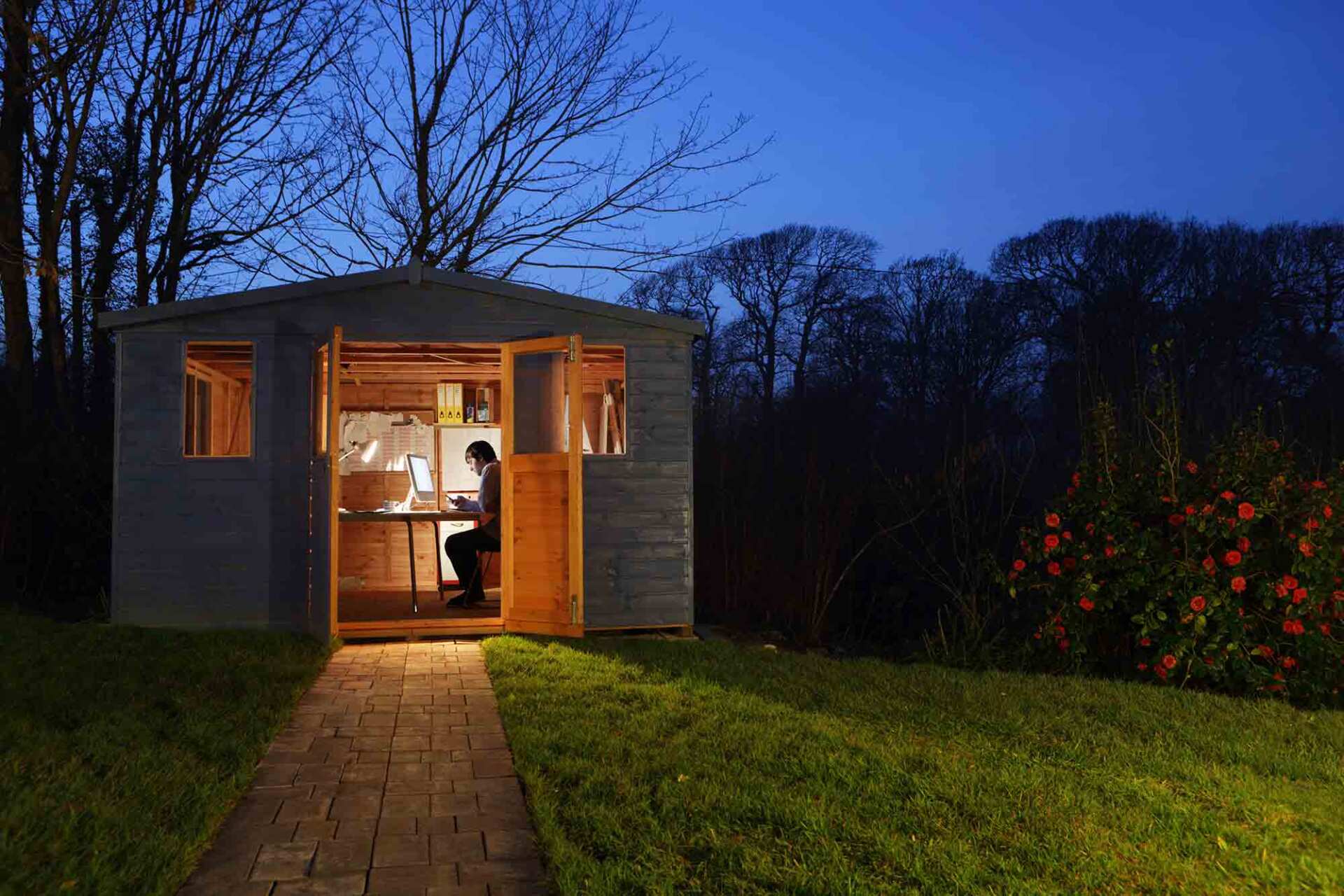 Man working in garden shed at night