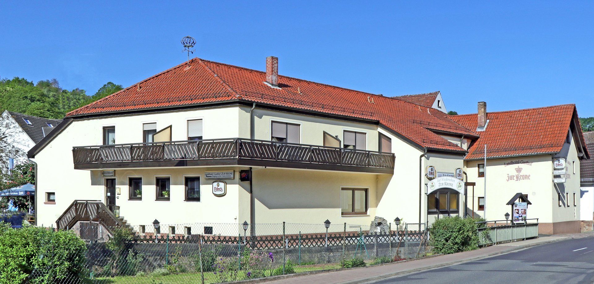 Ein großes weißes Haus mit einem roten Ziegeldach