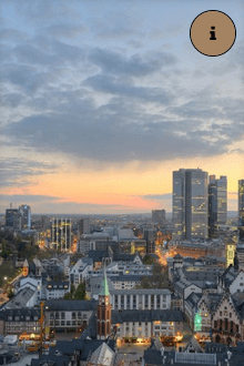 Eine Luftaufnahme einer Stadt mit einem Sonnenuntergang im Hintergrund.