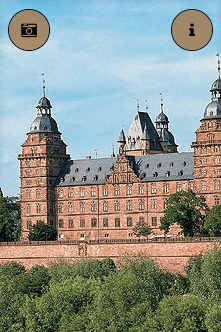 Ein großes Schloss, umgeben von Bäumen und einem Kamerasymbol
