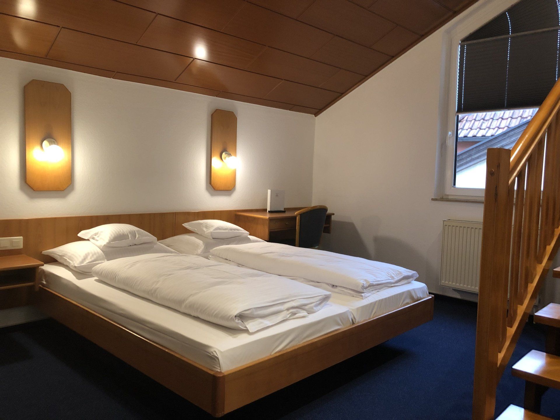 Ein Hotelzimmer mit zwei Betten und einer Treppe, die in den zweiten Stock führt