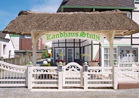 A thatched roof with a sign that says landhaus stutsi