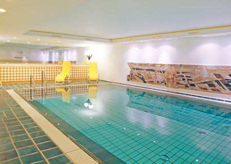 A large indoor swimming pool with chairs around it