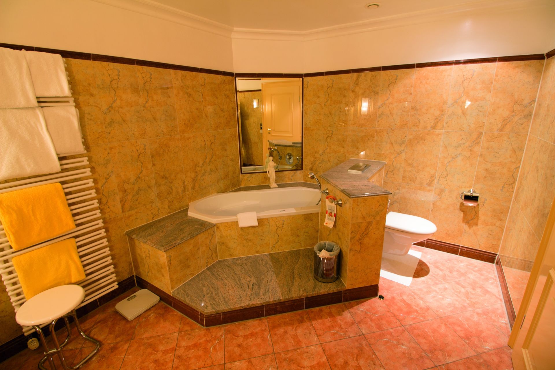 A bathroom with a tub , toilet , sink and mirror.