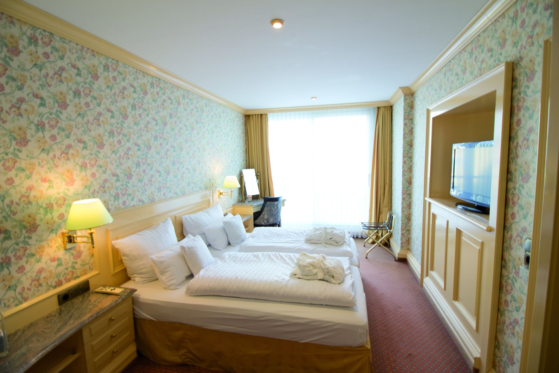 A hotel room with two beds and a television