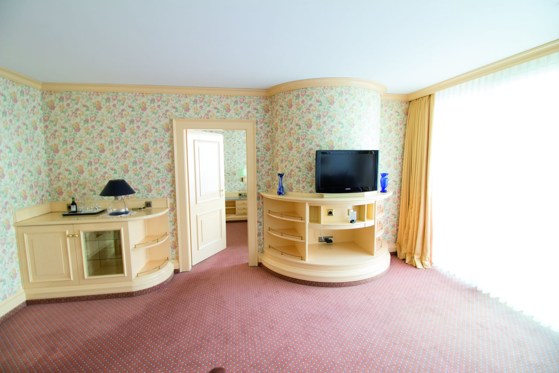 A large empty room with a flat screen tv on the wall.