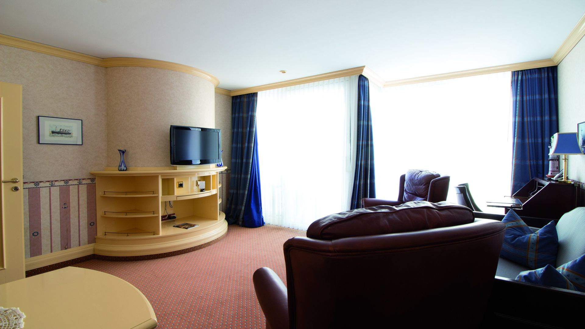 A living room with a couch and two televisions