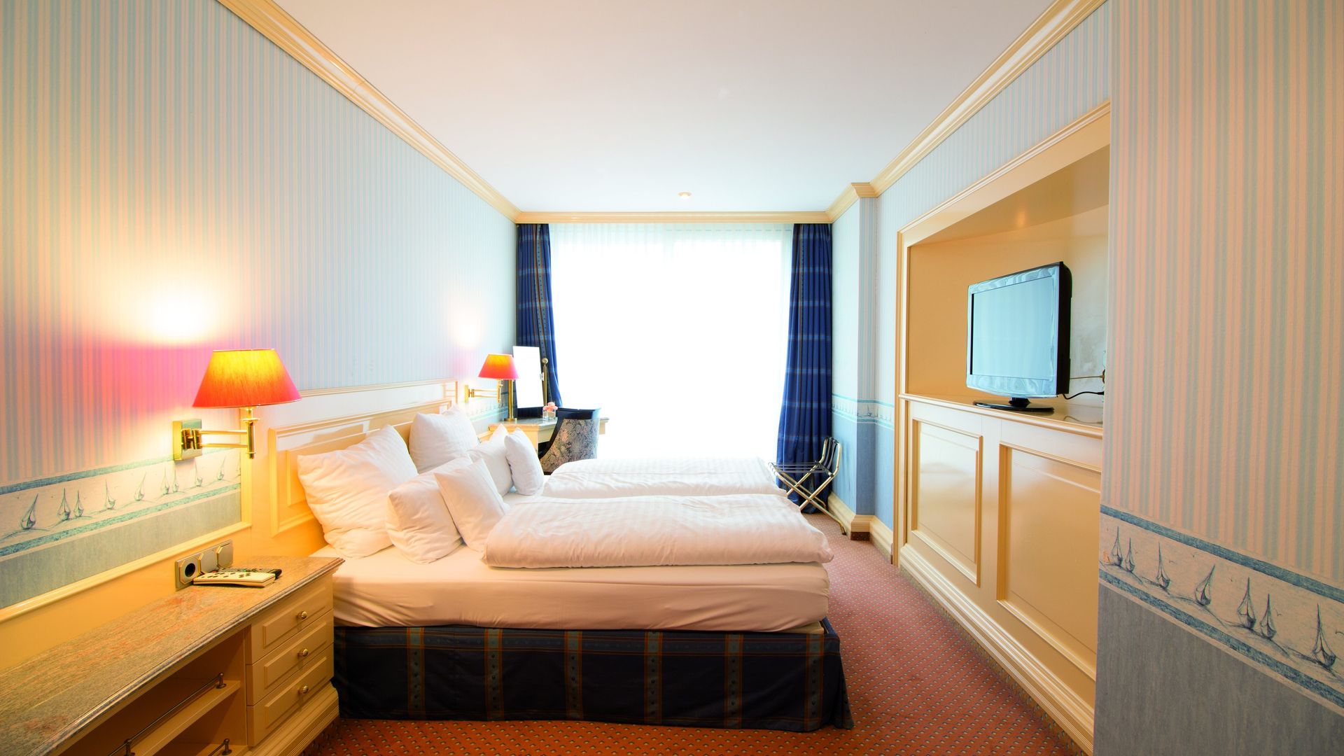 A hotel room with two beds and a flat screen tv.