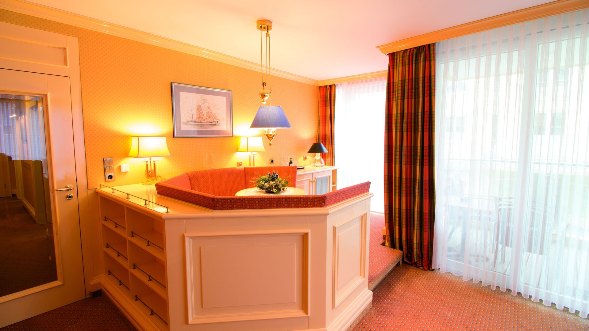 A hotel room with a large couch and a large window.