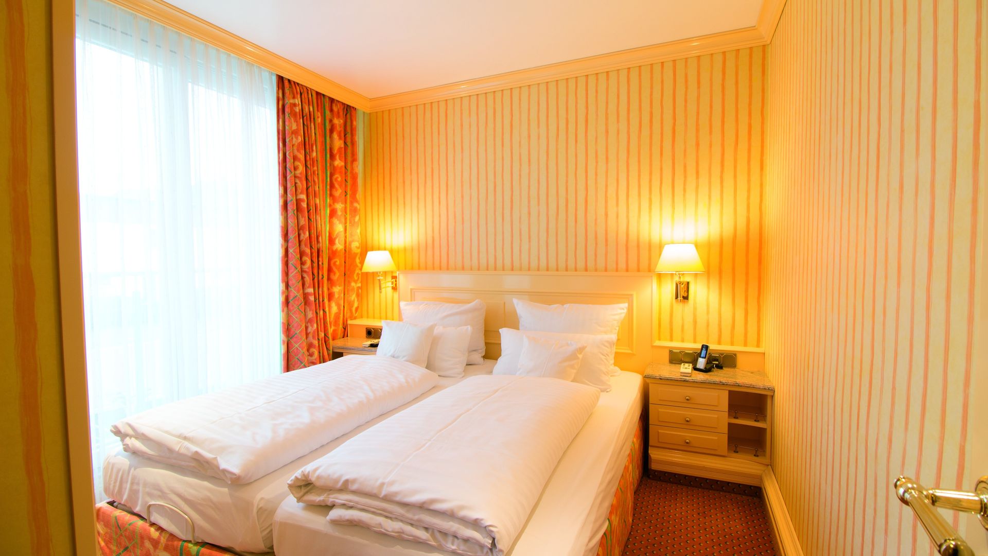 A hotel room with two beds and a window.