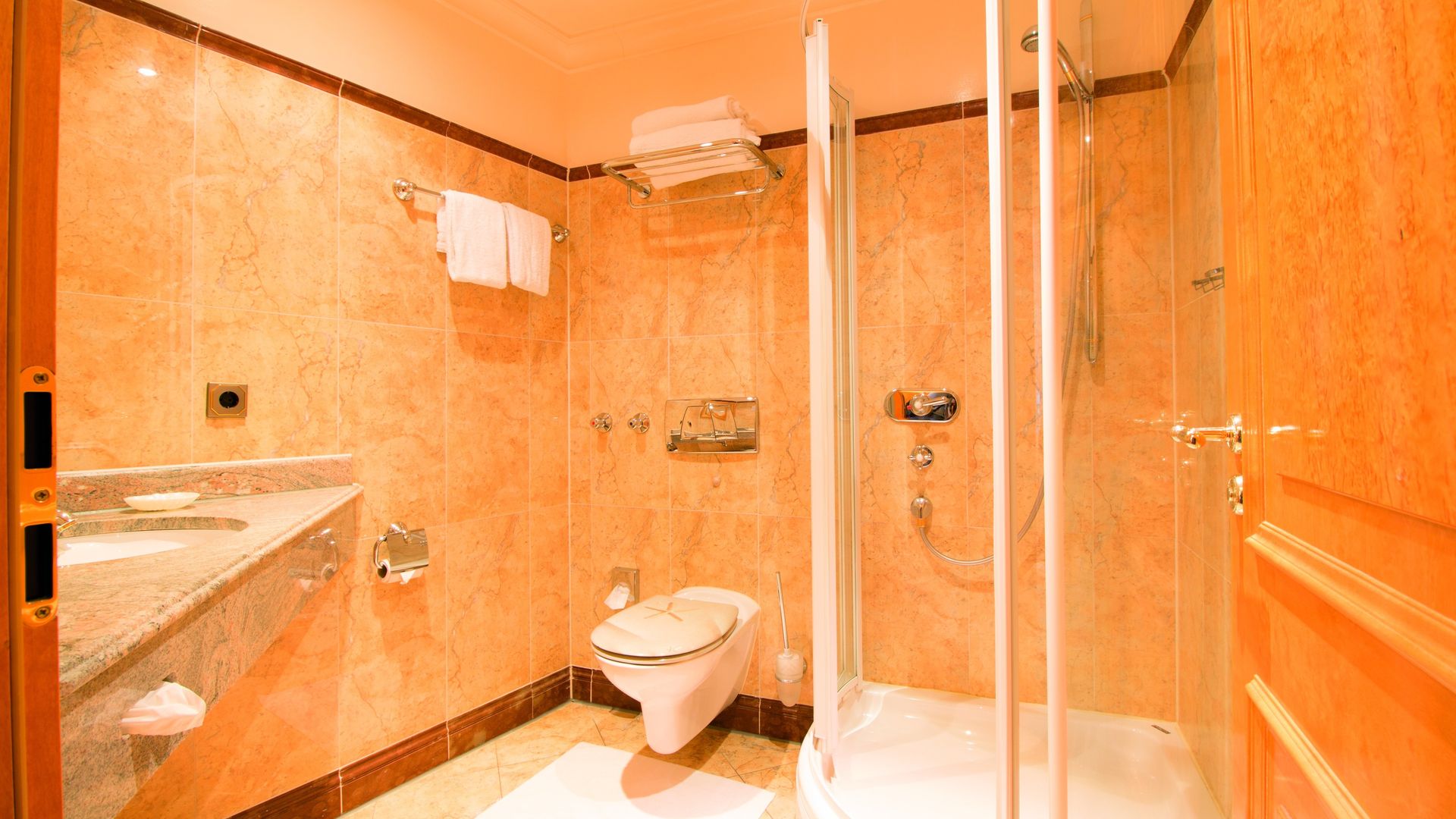 A bathroom with a toilet , sink and shower stall.
