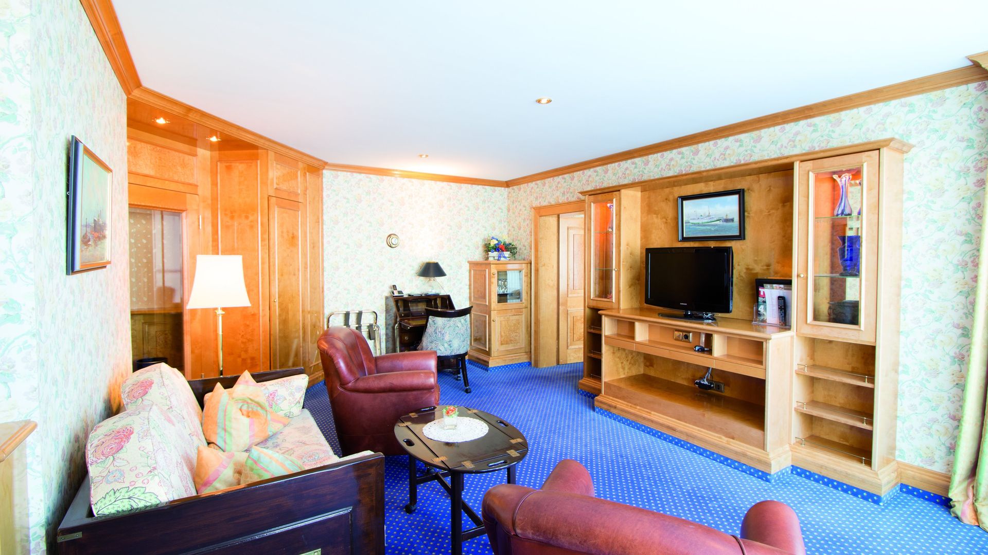 A living room with a couch , chairs , table and television.
