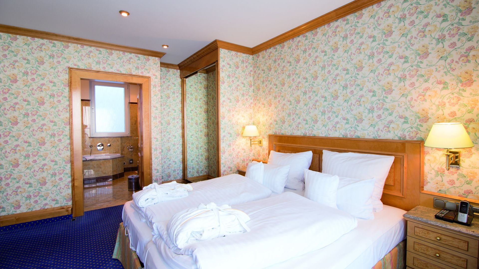 A hotel room with two beds and a bathroom.