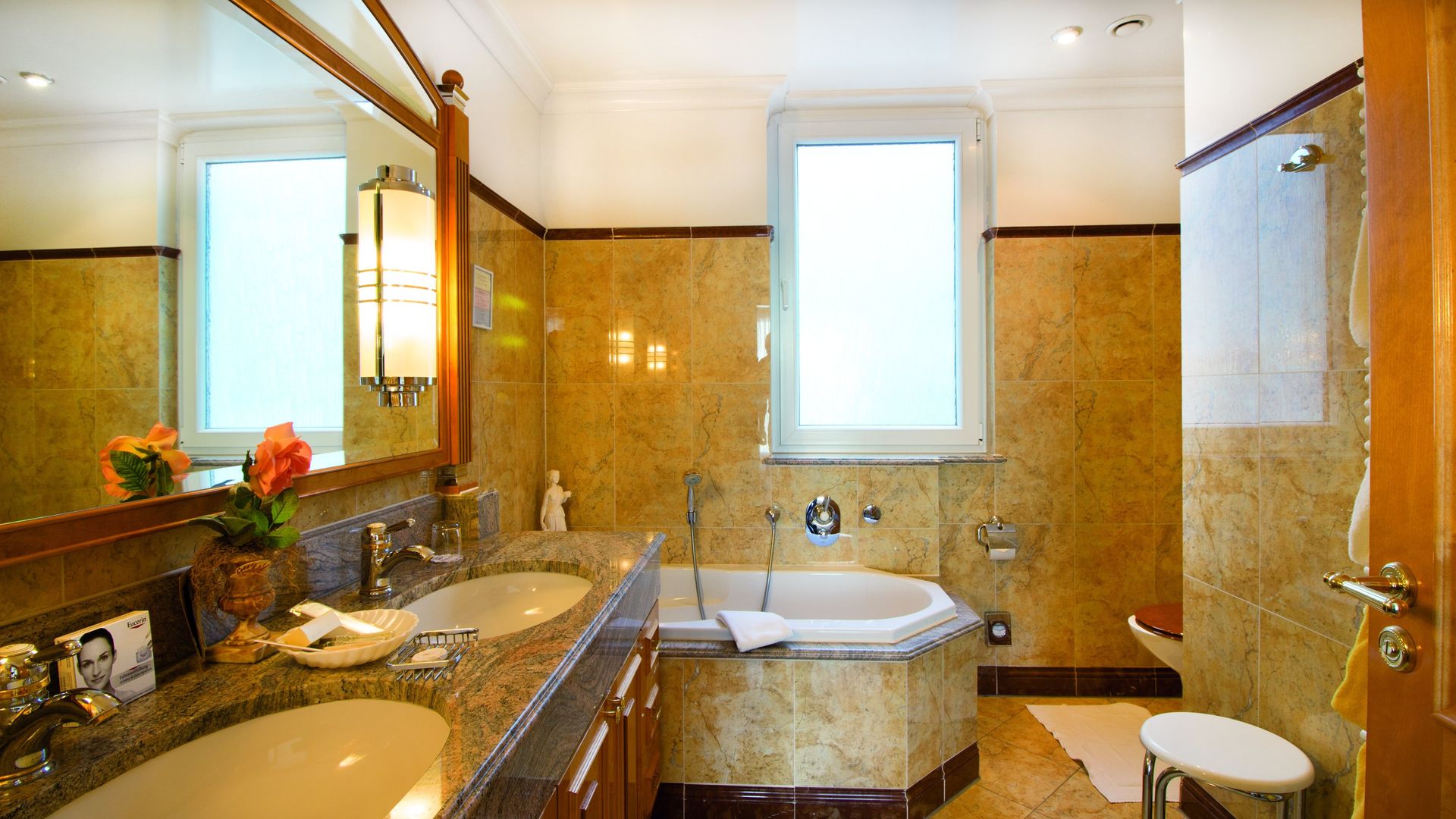 A bathroom with two sinks , a tub and a mirror.