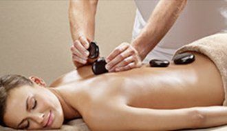 A woman is getting a hot stone massage at a spa.