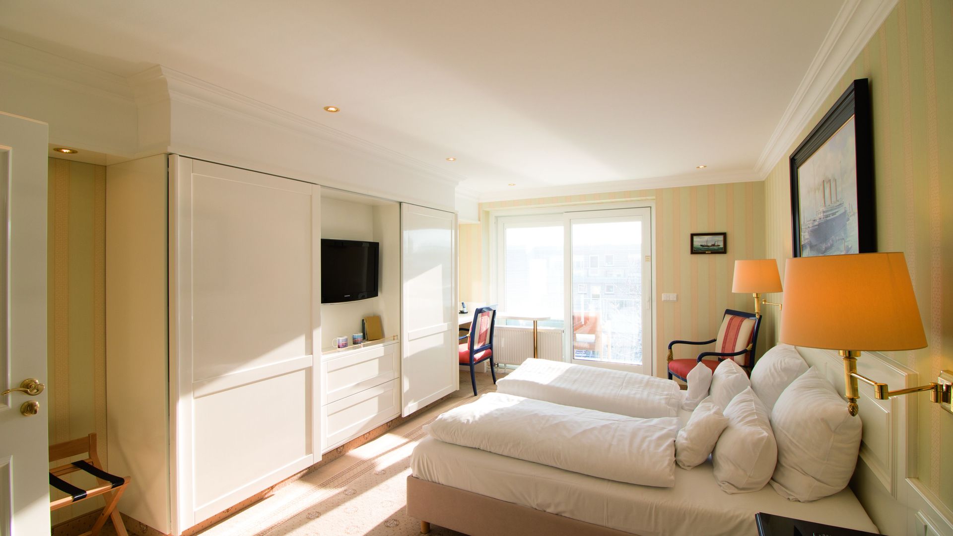 A hotel room with two beds and a television