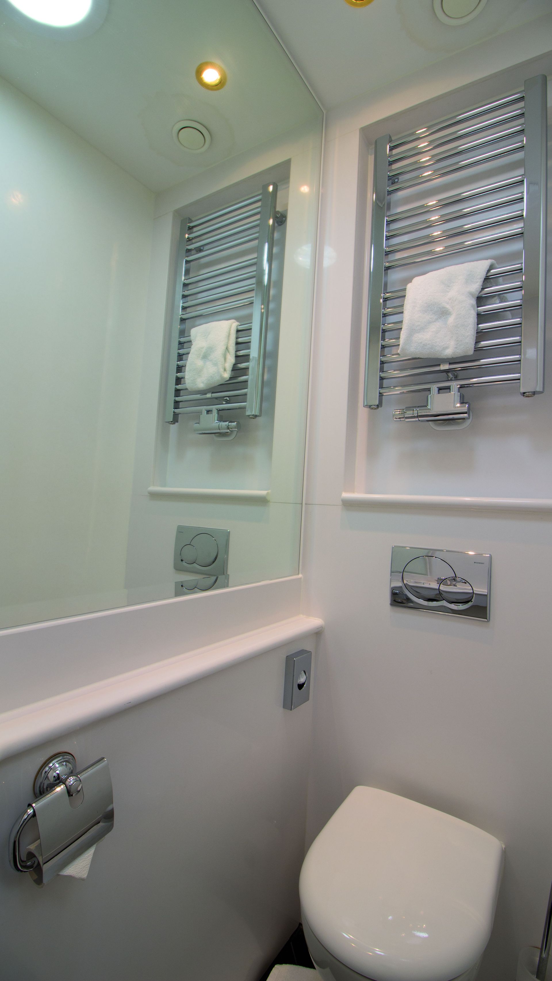 A bathroom with a toilet , sink and mirror.