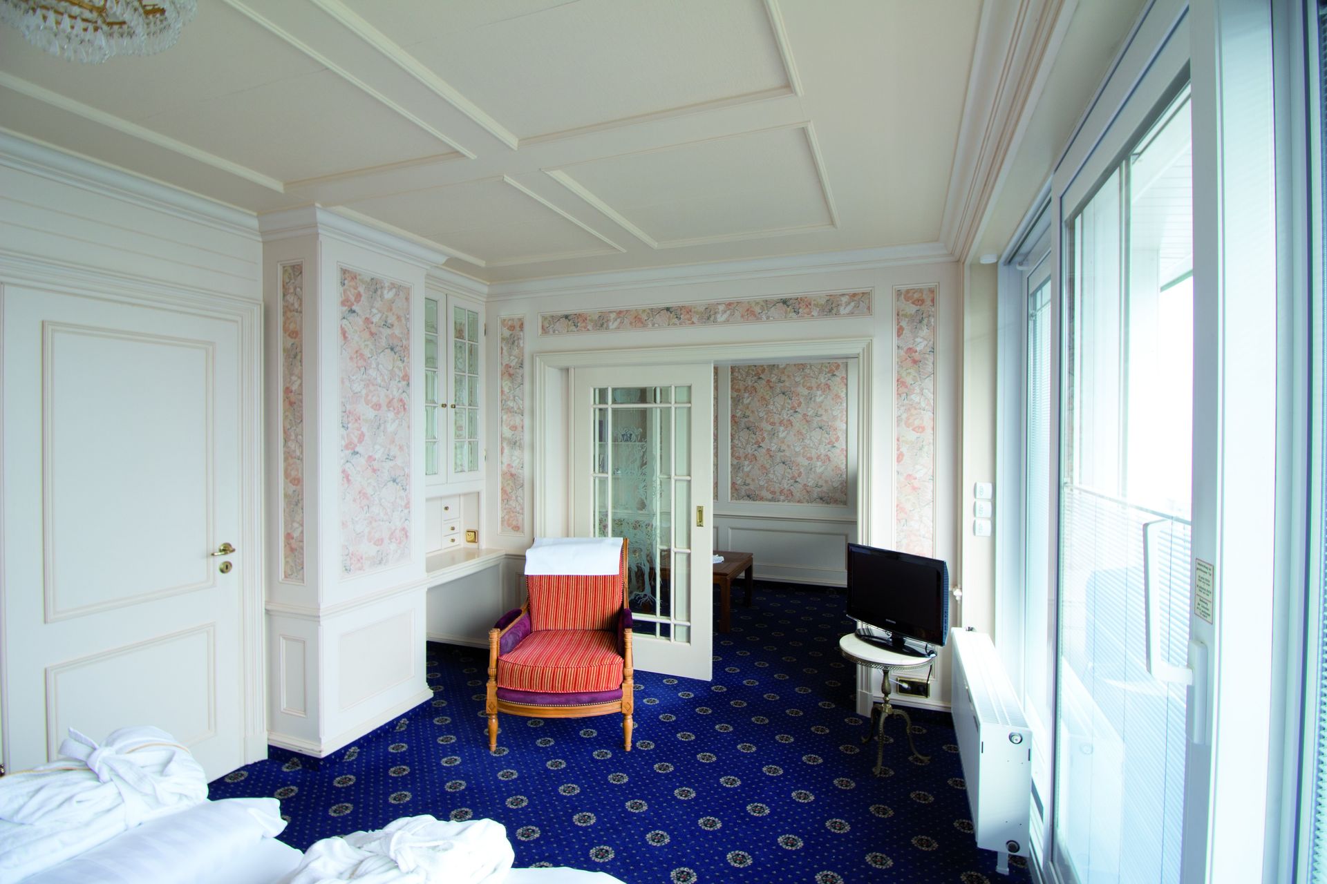 A hotel room with a bed , chair and television