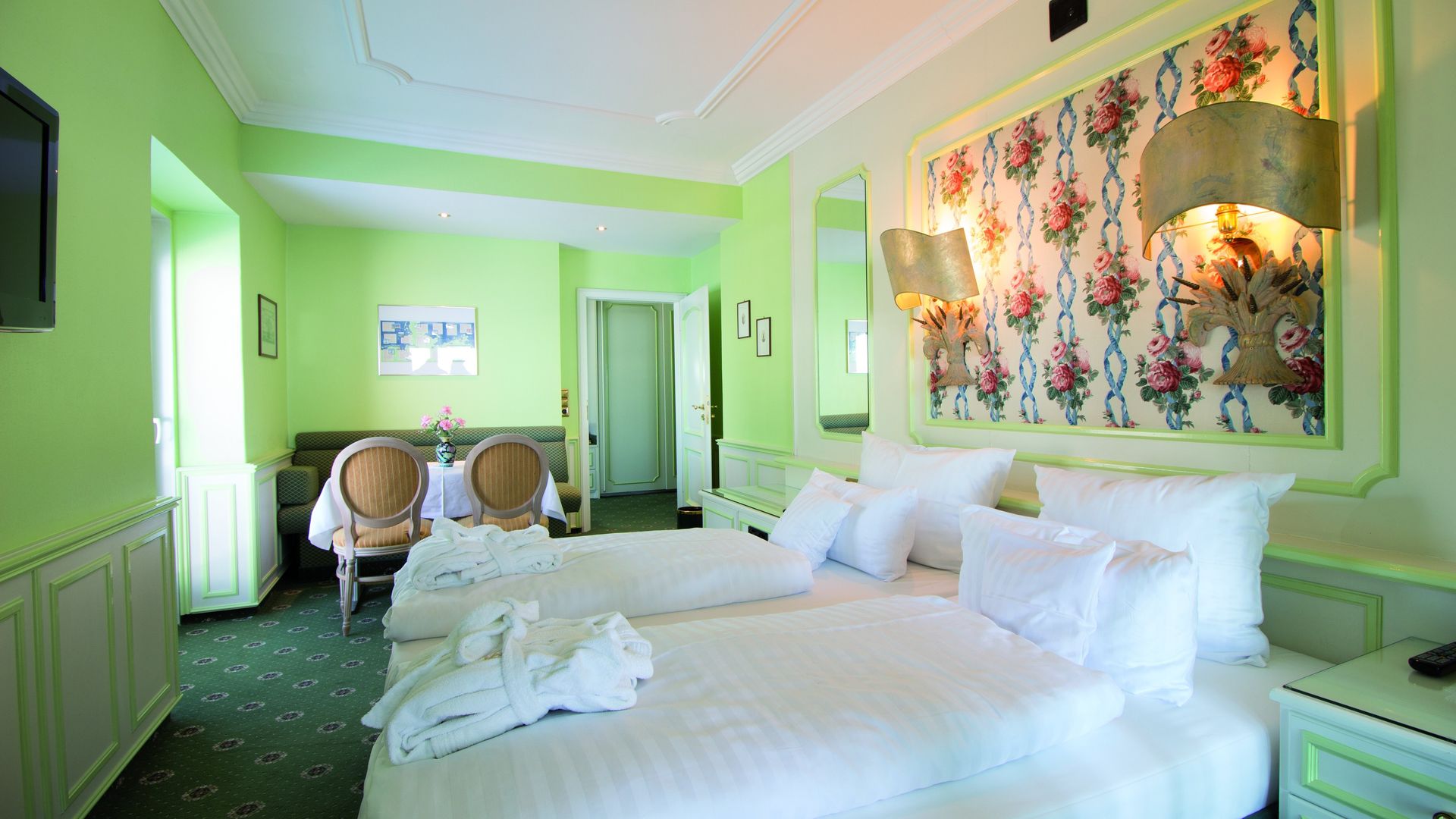 A hotel room with two beds , a chair and a television.