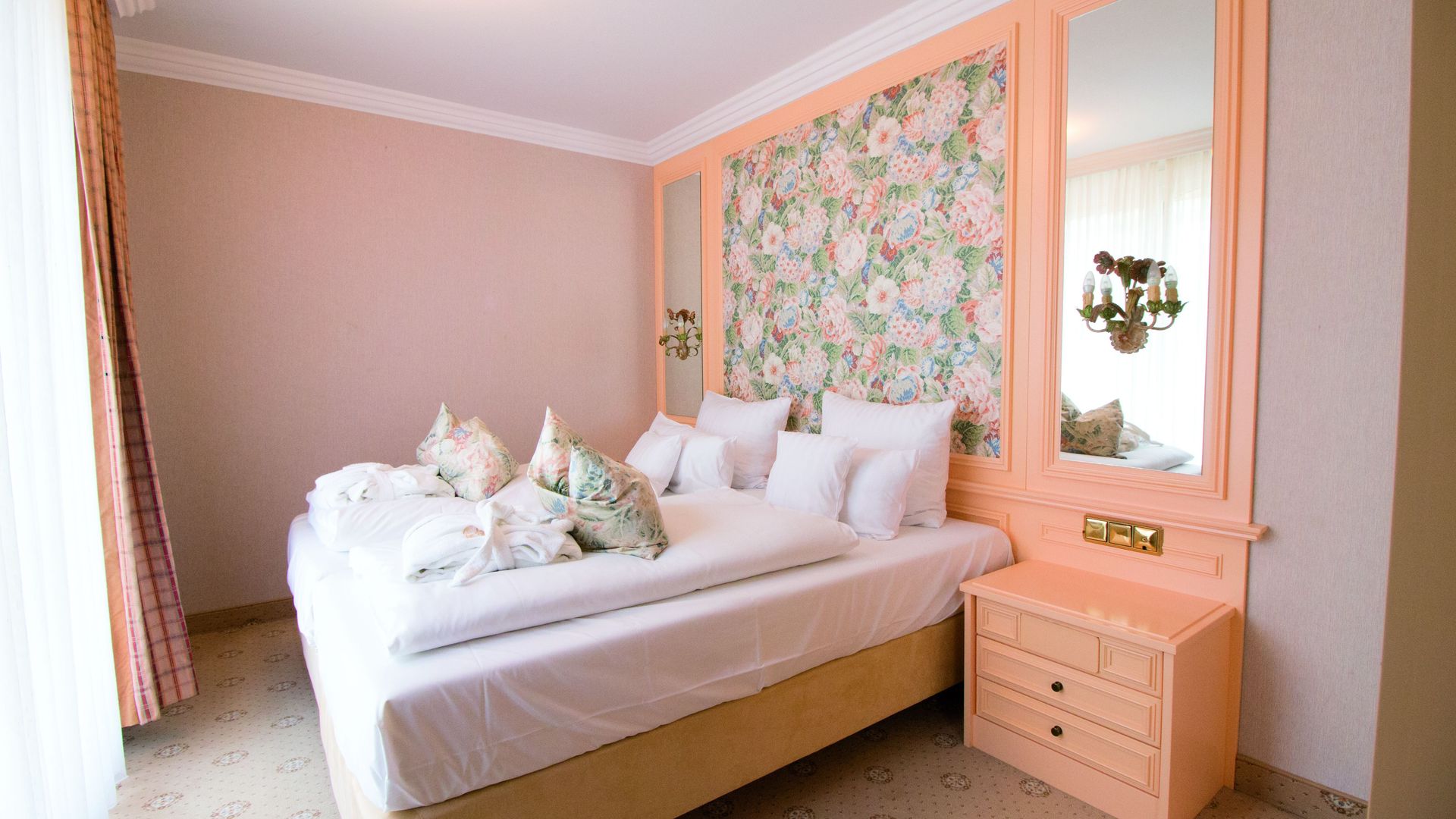 A hotel room with a large bed and a nightstand.