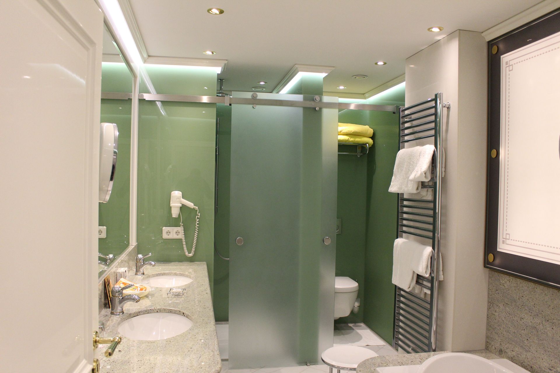 A bathroom with two sinks , a toilet , and a bathtub.