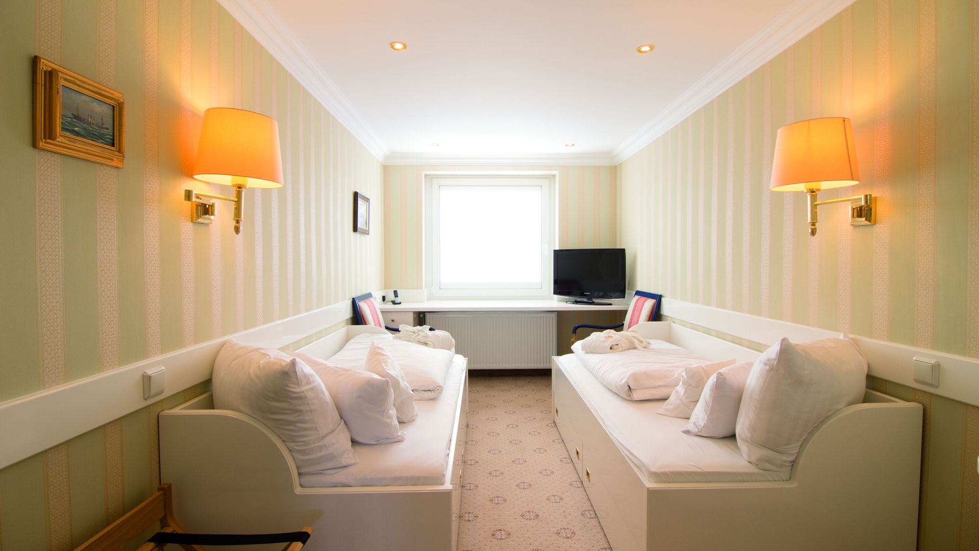 A hotel room with two beds and a television.