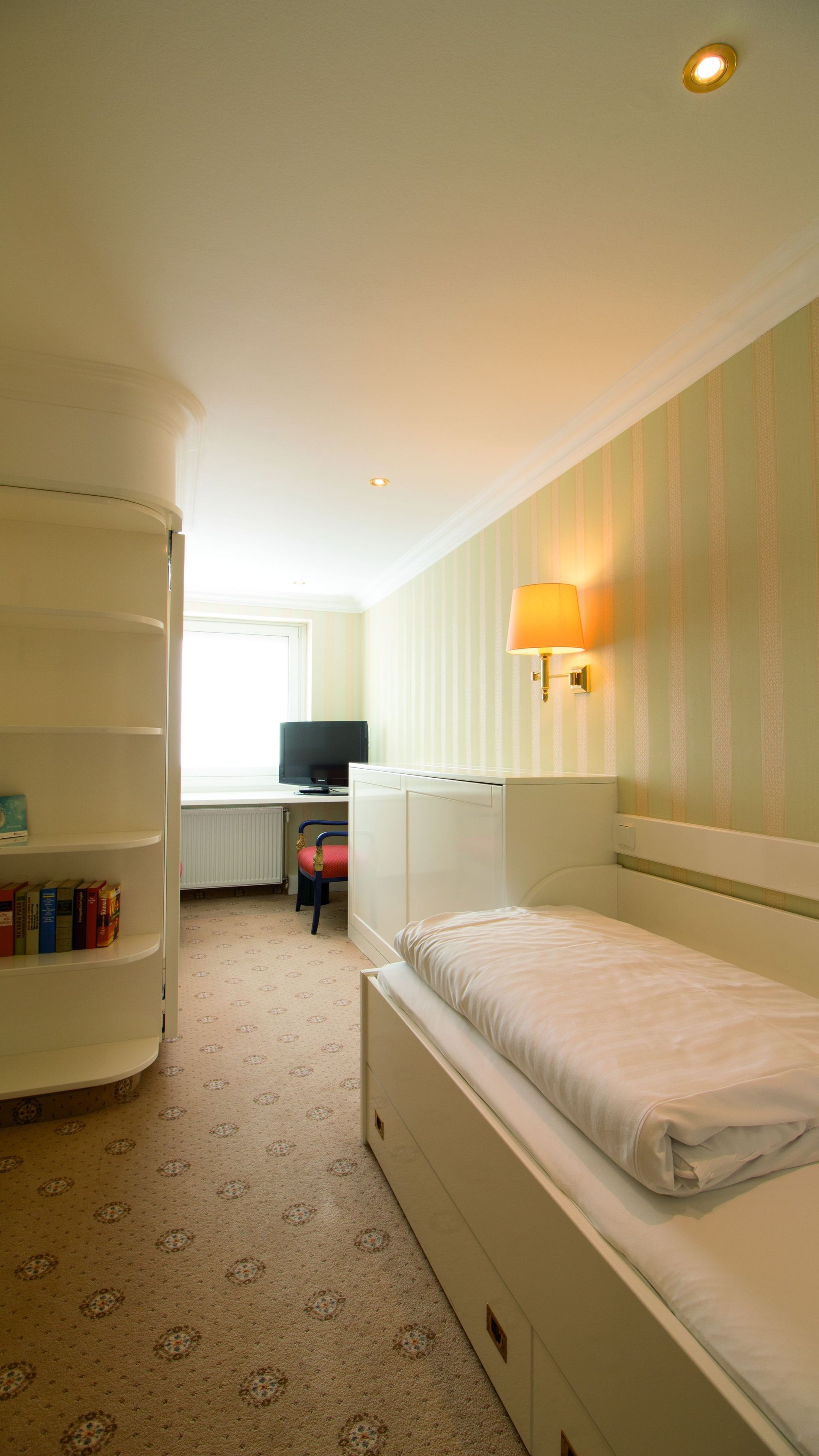 There is a single bed in the middle of the room.