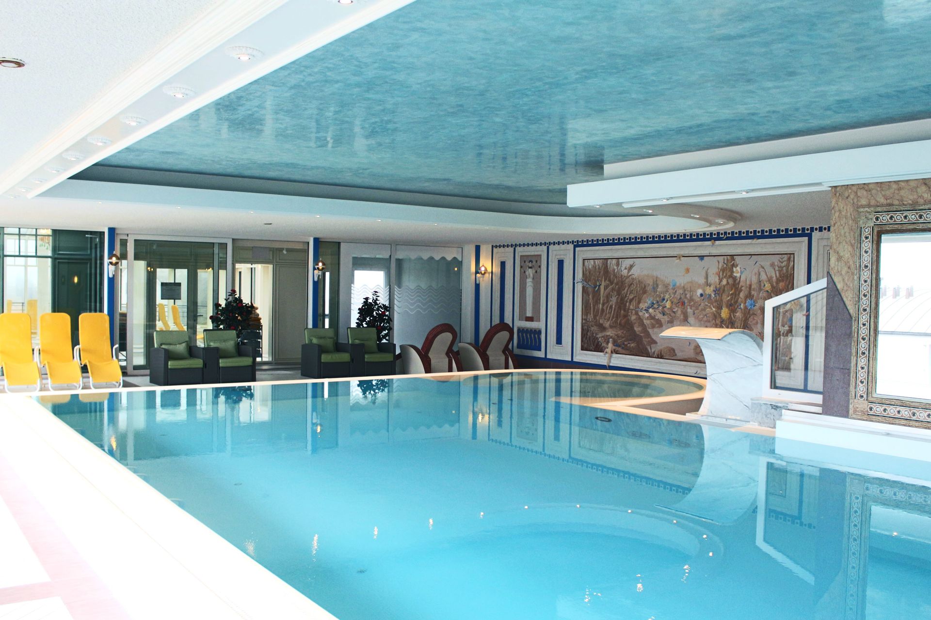 A large indoor swimming pool with a blue ceiling