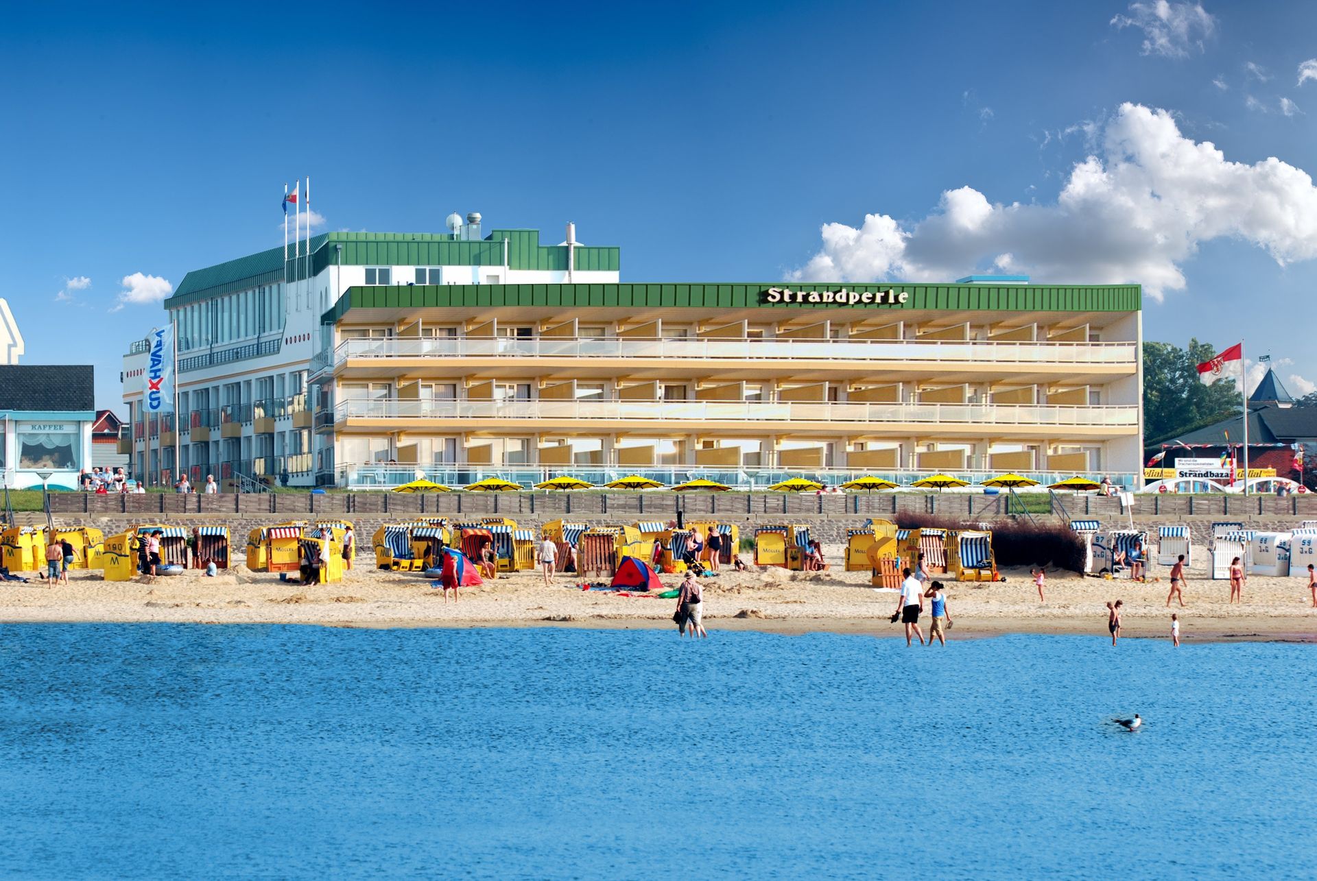 A large building on a beach with umbrellas in front of it
