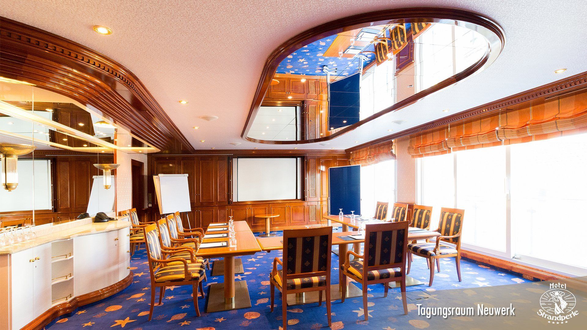A large room with tables and chairs and a projector screen