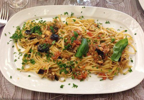 piatto di spaghetti con condimento di mare e prezzemolo