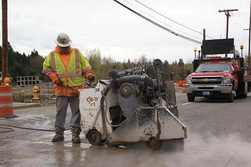 Worker cutting concrete street - Concrete cutting in Milton, WA