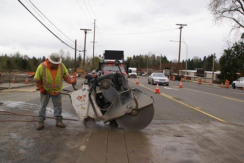 Man cutting concrete street - National Concrete Cutting in Milton, WA