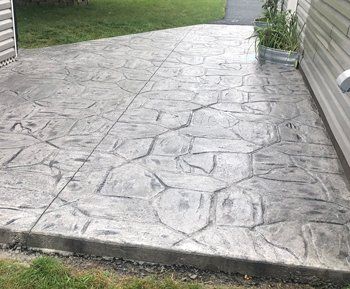 Universal Paving & Concrete’s stamped concrete patio in Rochester, NY, designed to mimic the appearance of natural stone, offering an affordable alternative.