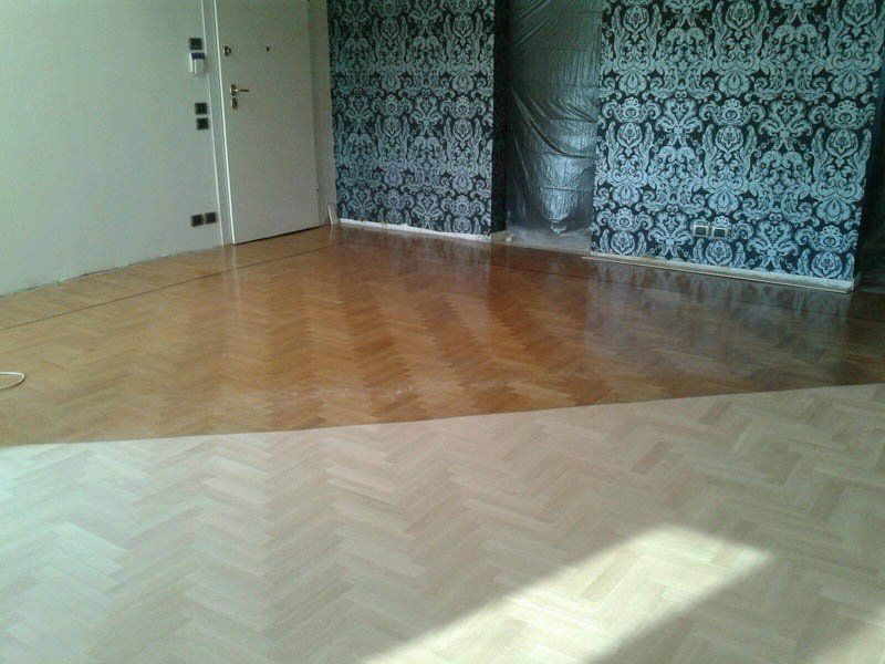stanza con parquet a spina di pesce e pareti con carta da parati