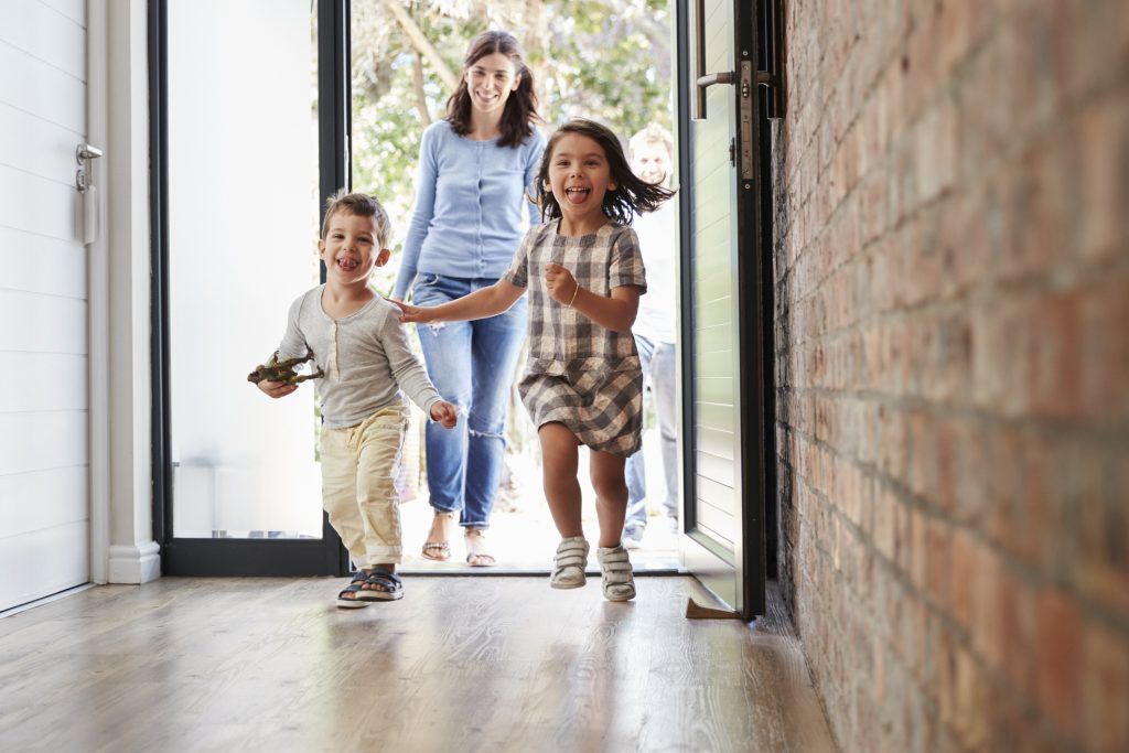 Excited Children Arriving Home With Parents