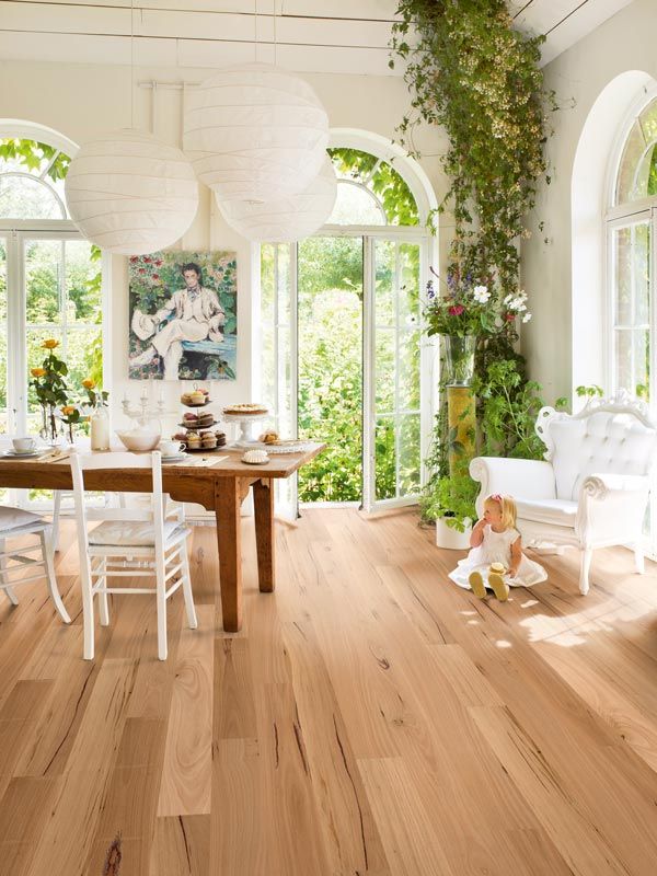 dining room with lots of plants and light timber floors