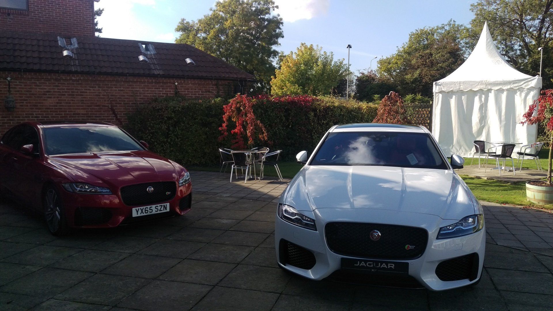 A red car and a white car are parked next to each other