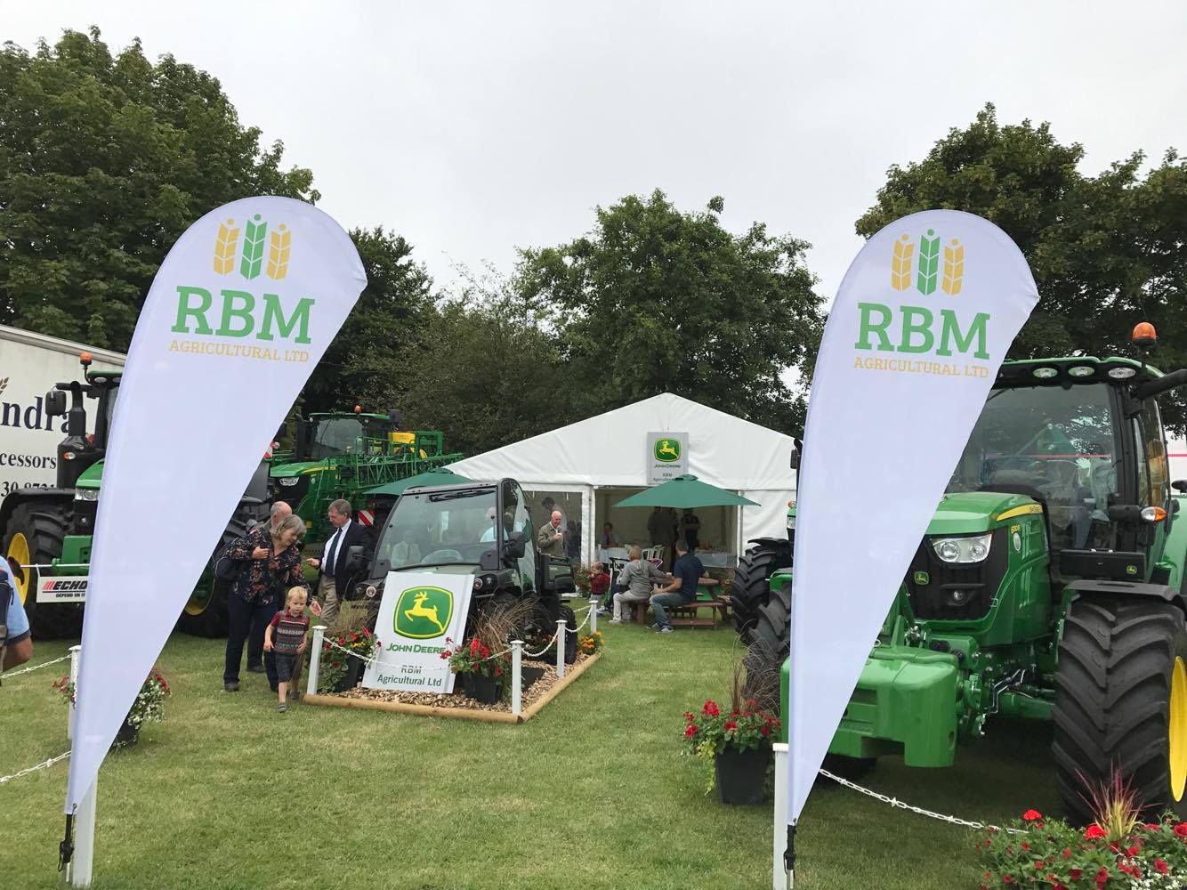 A john deere tractor is parked in front of a tent.