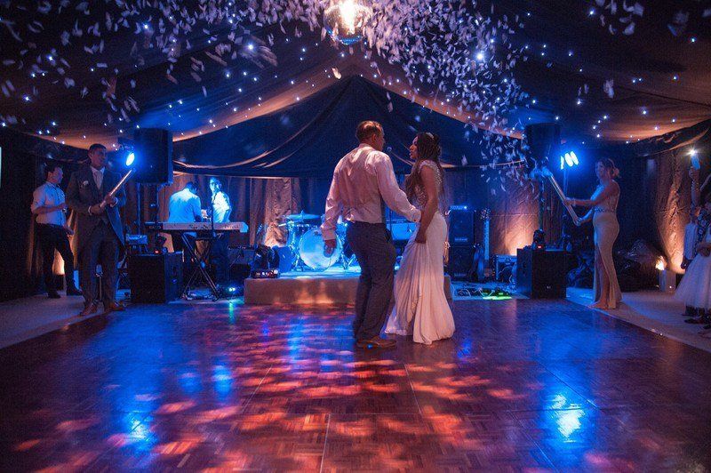 A bride and groom are dancing on a dance floor at a wedding reception.