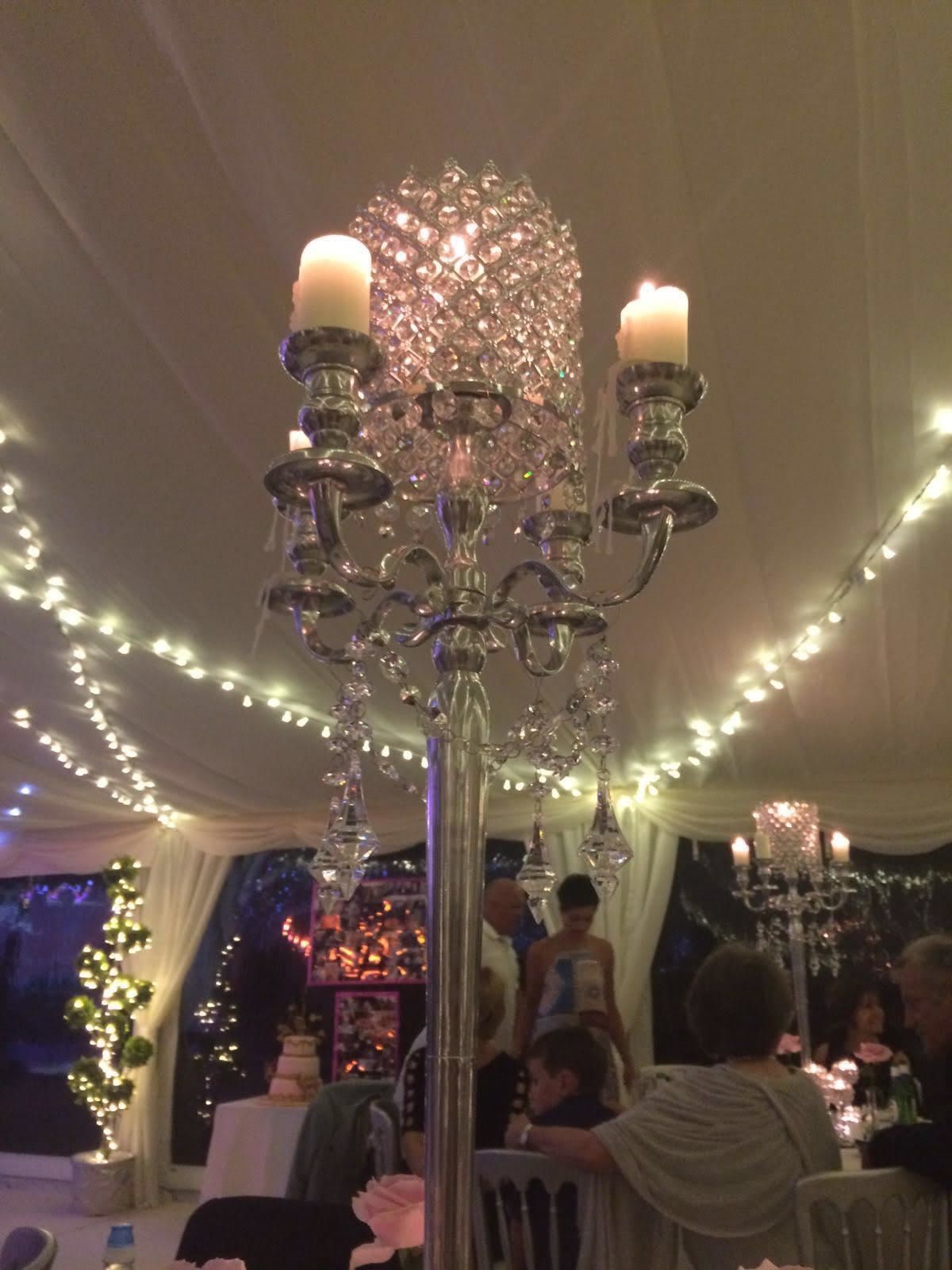 A chandelier with candles hanging from it in a room