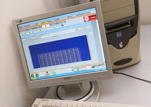 Monitor di un computer desktop che mostra una finestra software blu su una scrivania vicino a una CPU a torre