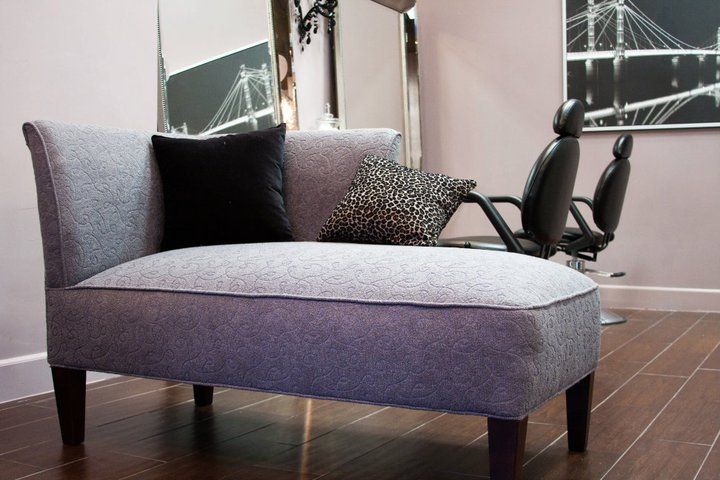 A chaise lounge in a room with a picture of a bridge on the wall