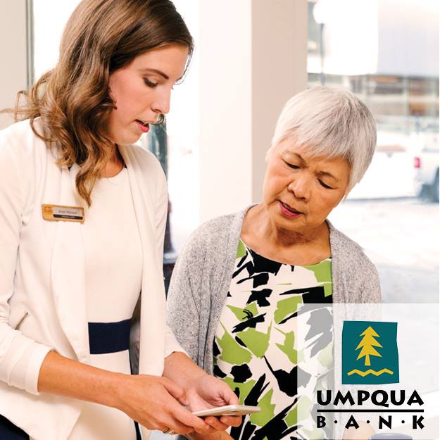 A woman talking to an older woman with a umpqua bank logo in the background