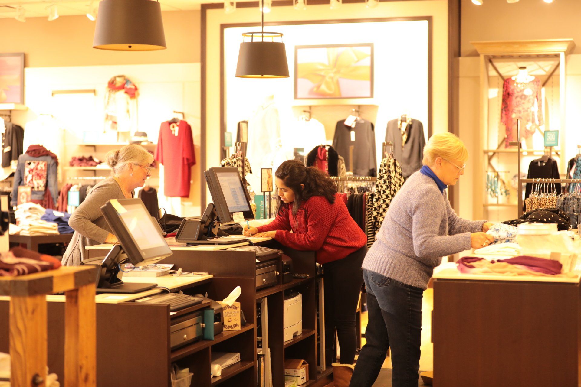 A group of women are working in a clothing store.
