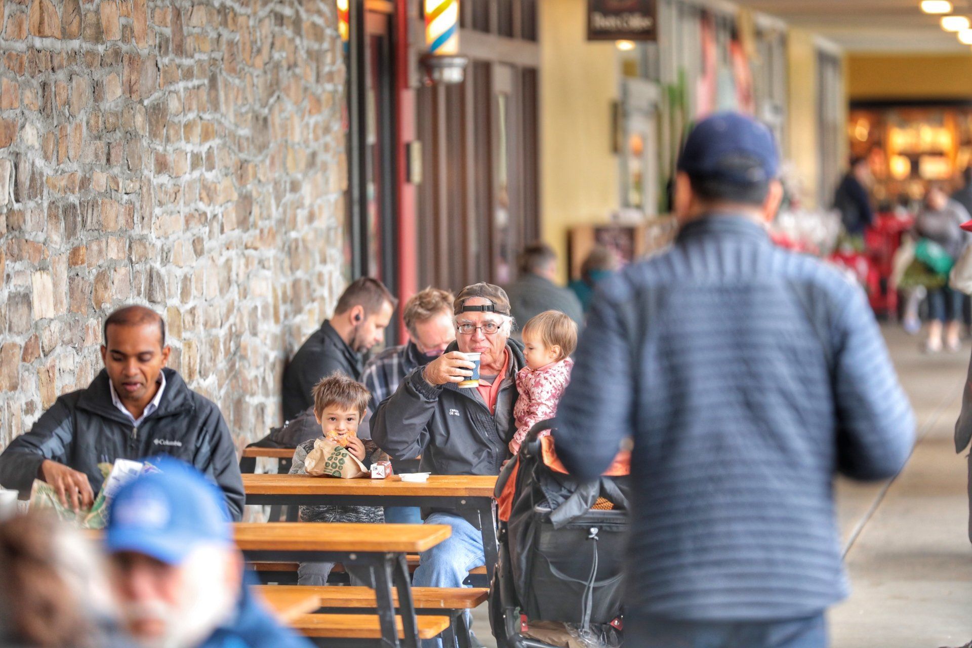 A group of people are sitting at tables outside of a building.