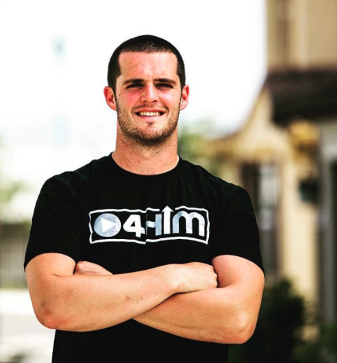 A man with his arms crossed wearing a black shirt that says 041m