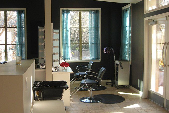 A salon with black chairs and blue curtains